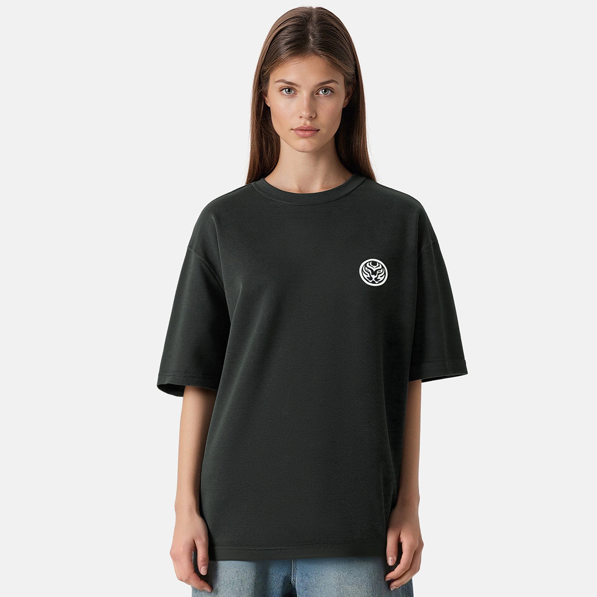 Person wearing a black t-shirt with a small logo on a plain background