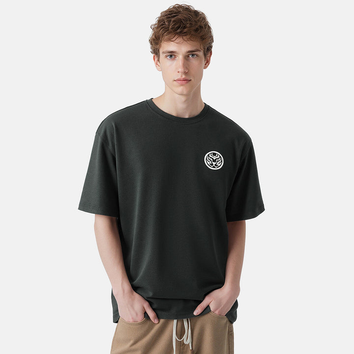 Person wearing a black t-shirt with a logo on a white background