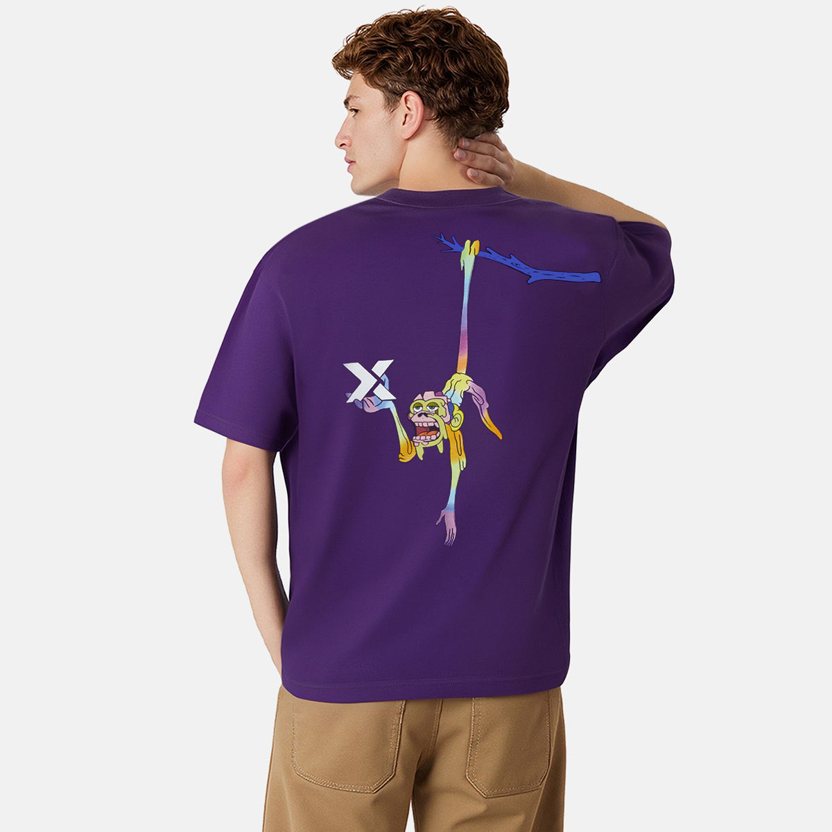 Person wearing a purple t-shirt with colorful designs on the back, standing against a white background