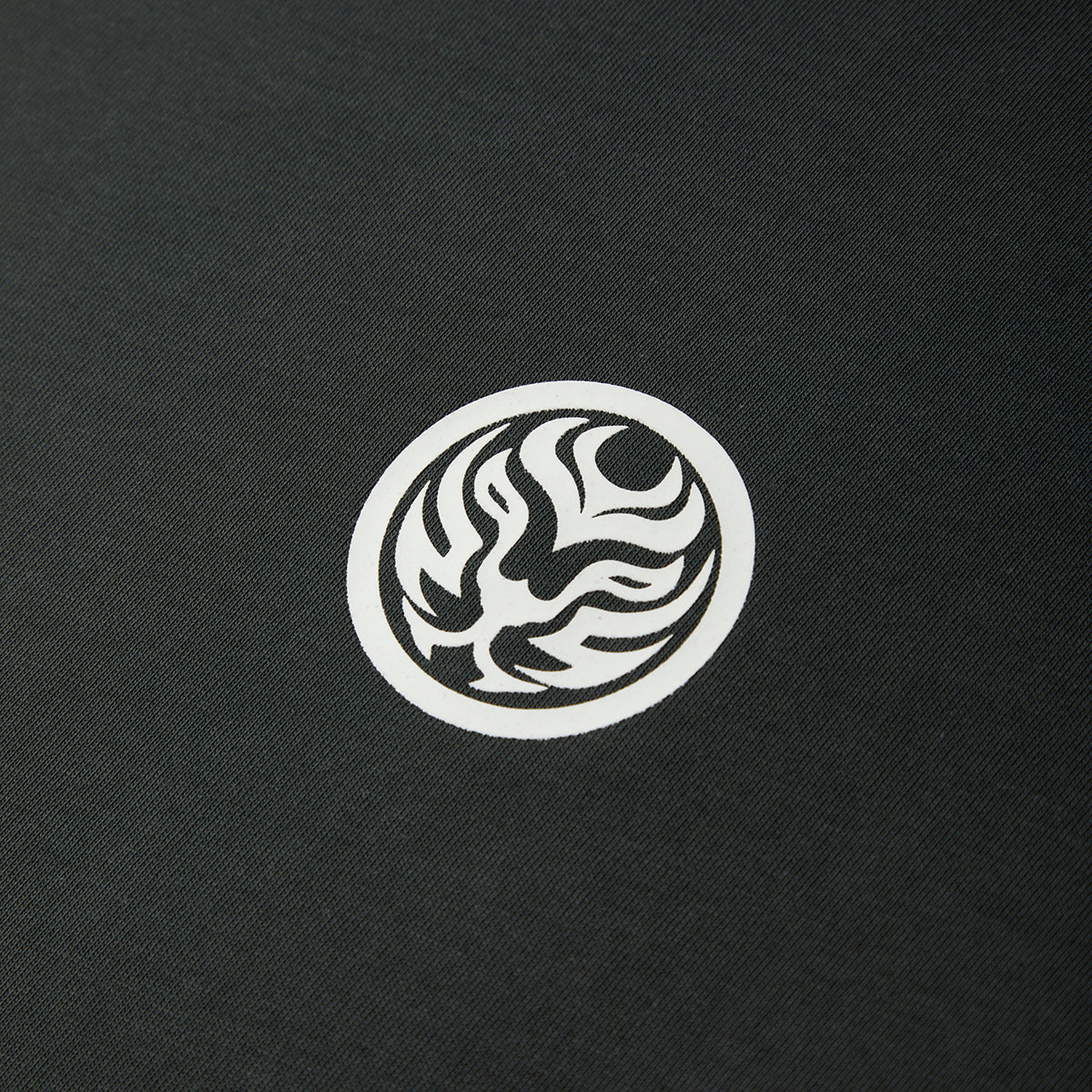 White circular logo with abstract design on a black textured background
