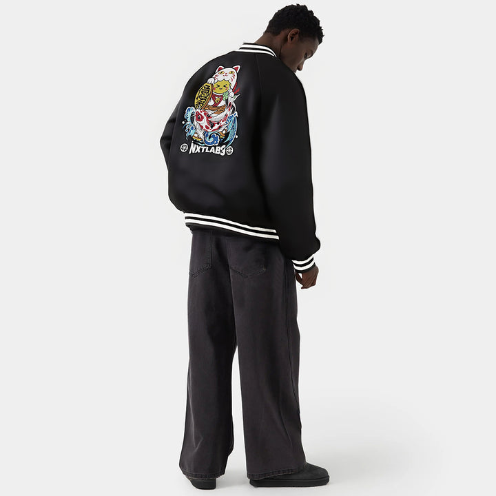 Person wearing a black jacket with colorful graphics on the back, standing against a white background