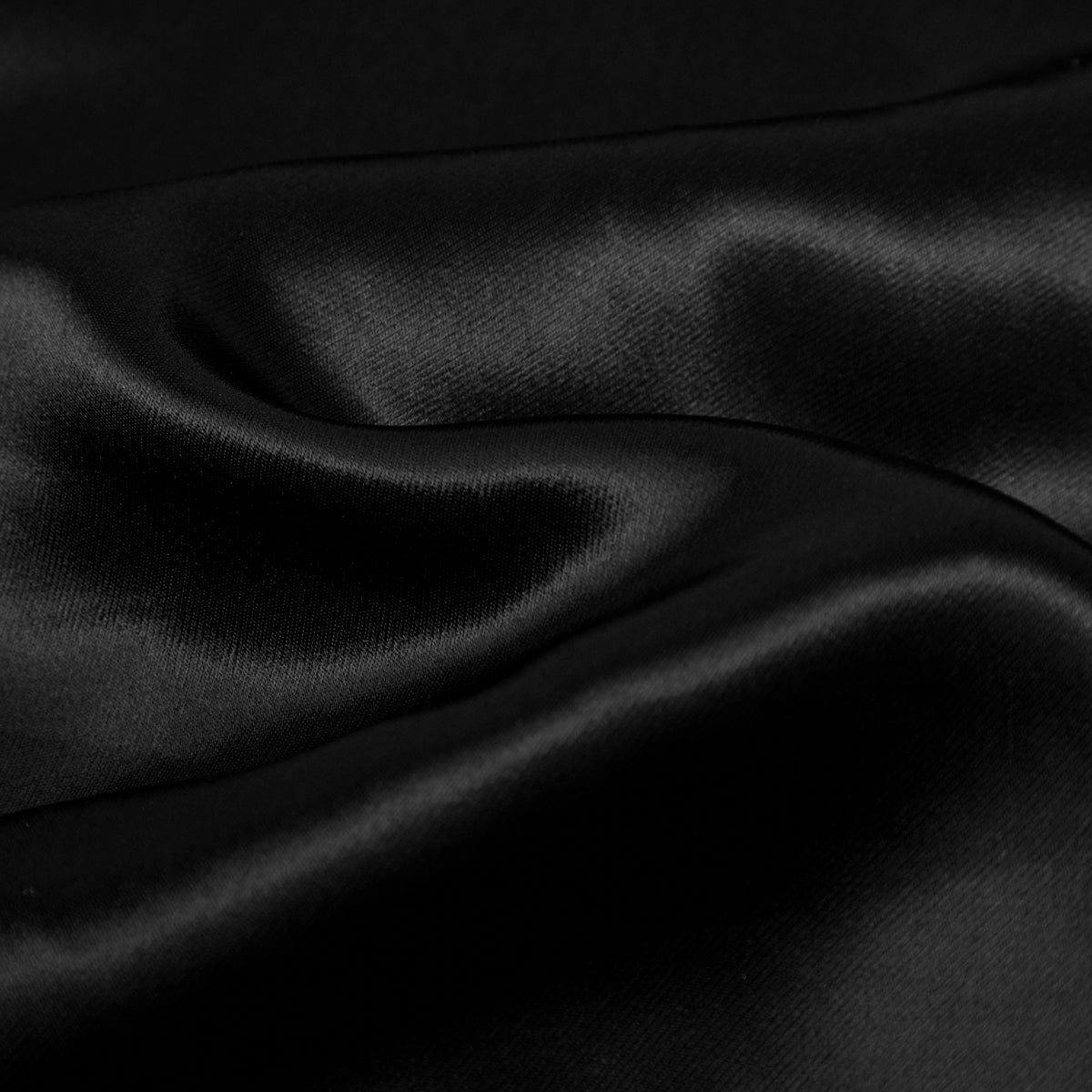 Close-up of black satin fabric with folds