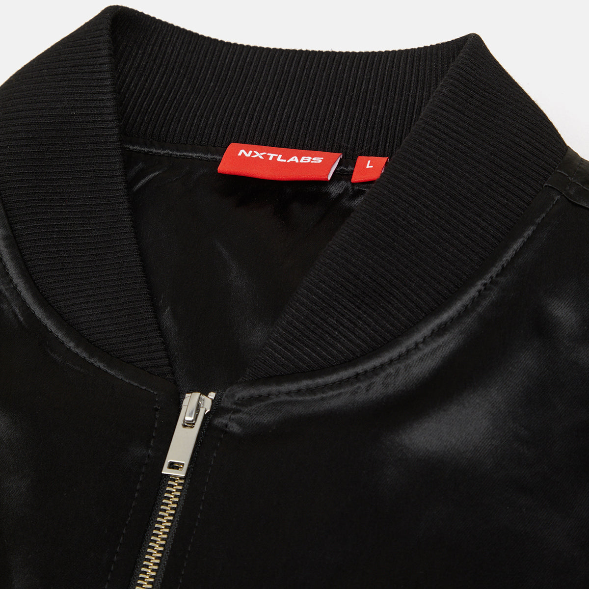 Black jacket with a red label on the collar, featuring the brand 'NXTLABS'.