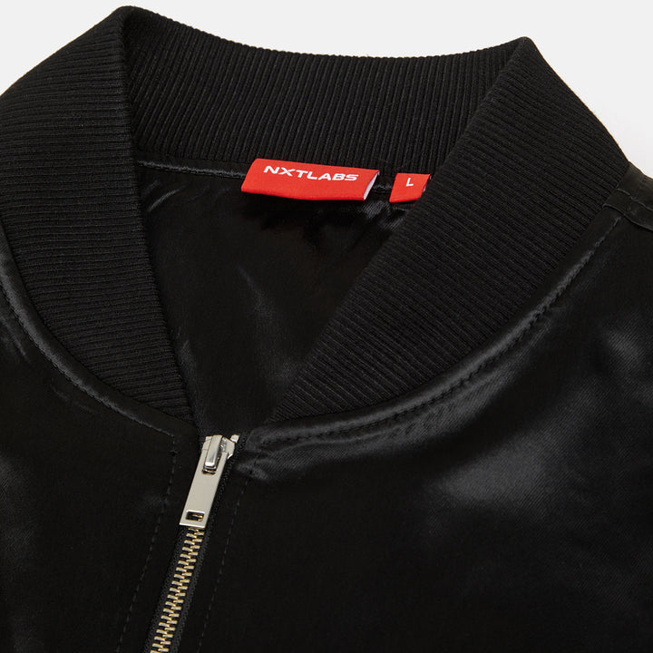 Black jacket with a red label on the collar, featuring the brand 'NXTLABS'.