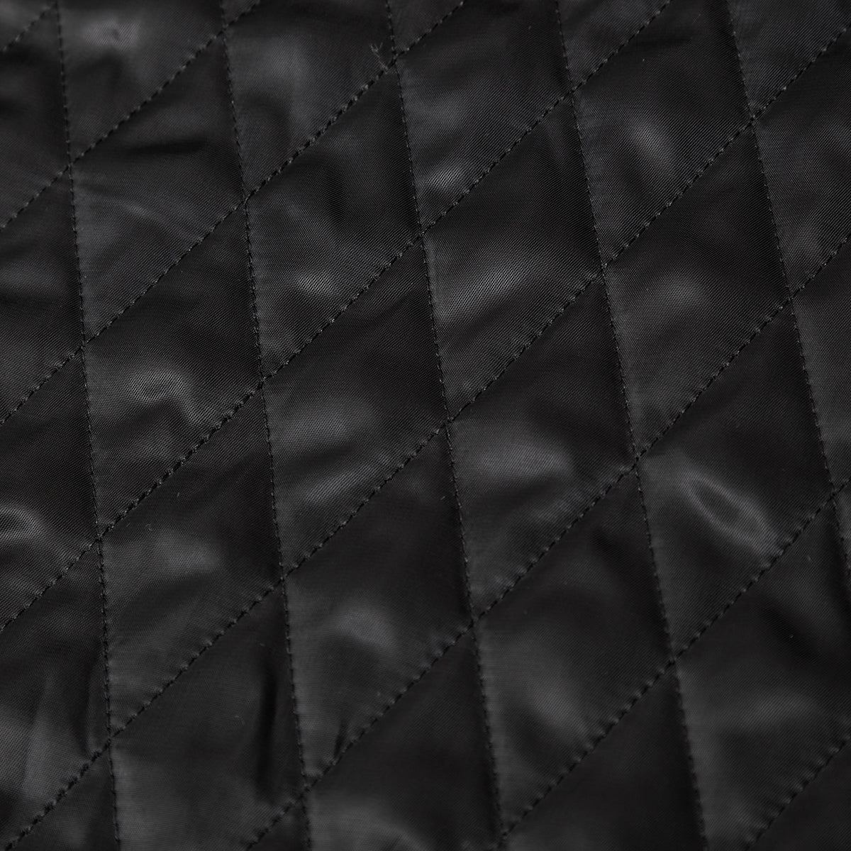 Close-up of black quilted fabric with diamond pattern
