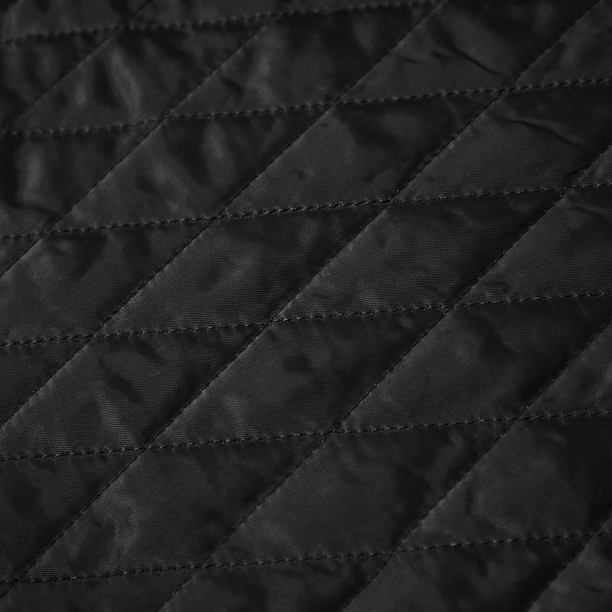 Close-up of black quilted fabric with diagonal stitching pattern