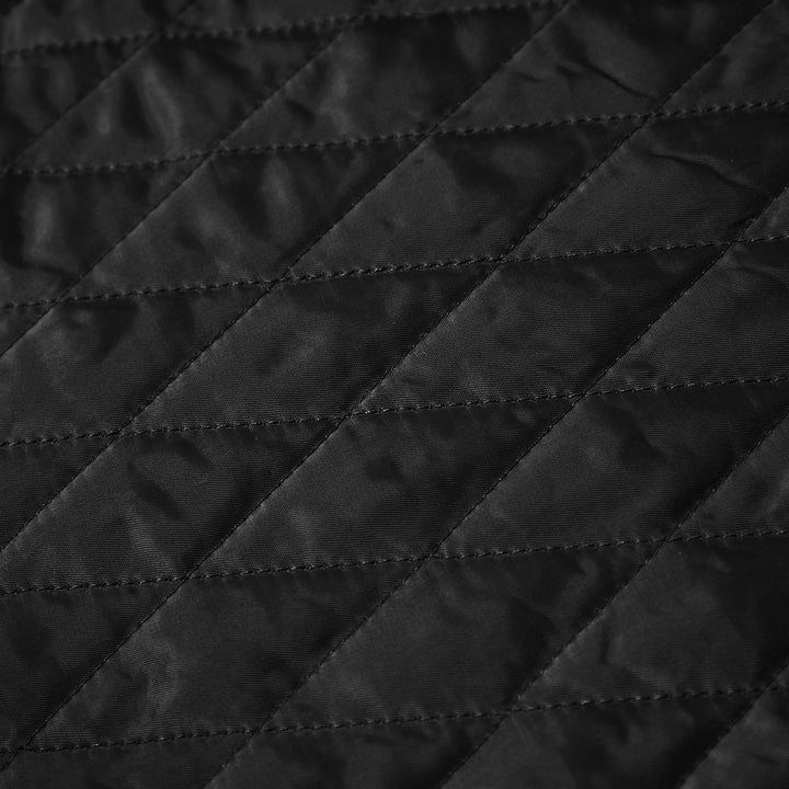 Close-up of black quilted fabric with diagonal stitching pattern