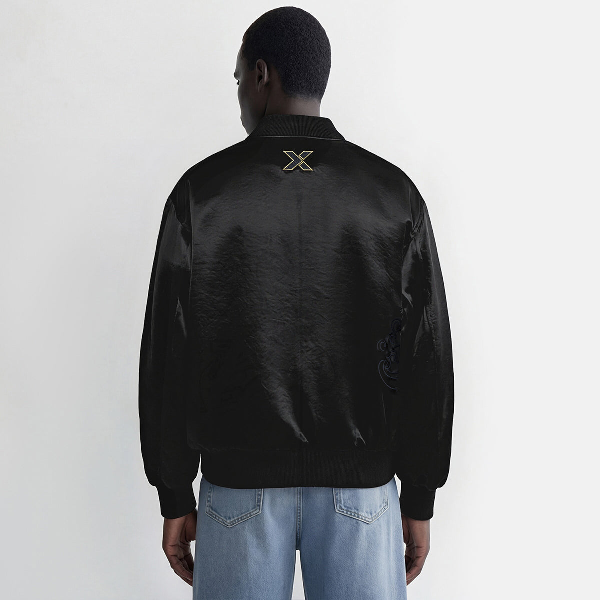 Person wearing a black jacket with a logo on the back against a white background