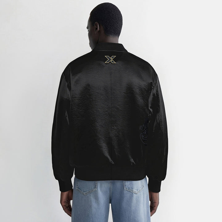 Person wearing a black jacket with a logo on the back against a white background
